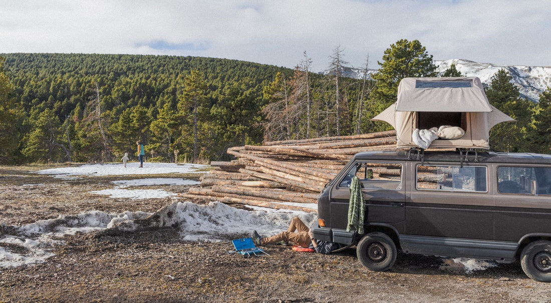 A man working under his VW van in the snow